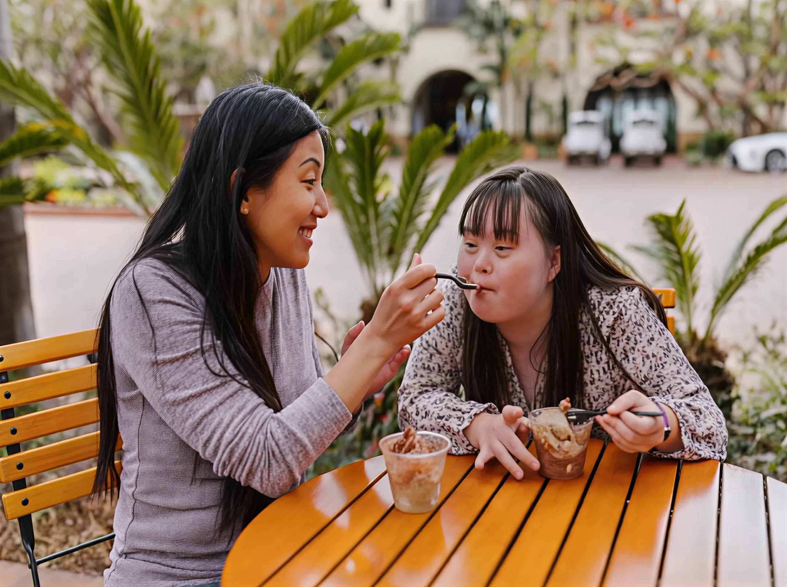 A Utmost Solutions WA support worker sharing a friendly moment with an NDIS participant in a sunny Rockingham lounge room, demonstrating genuine person-centred care